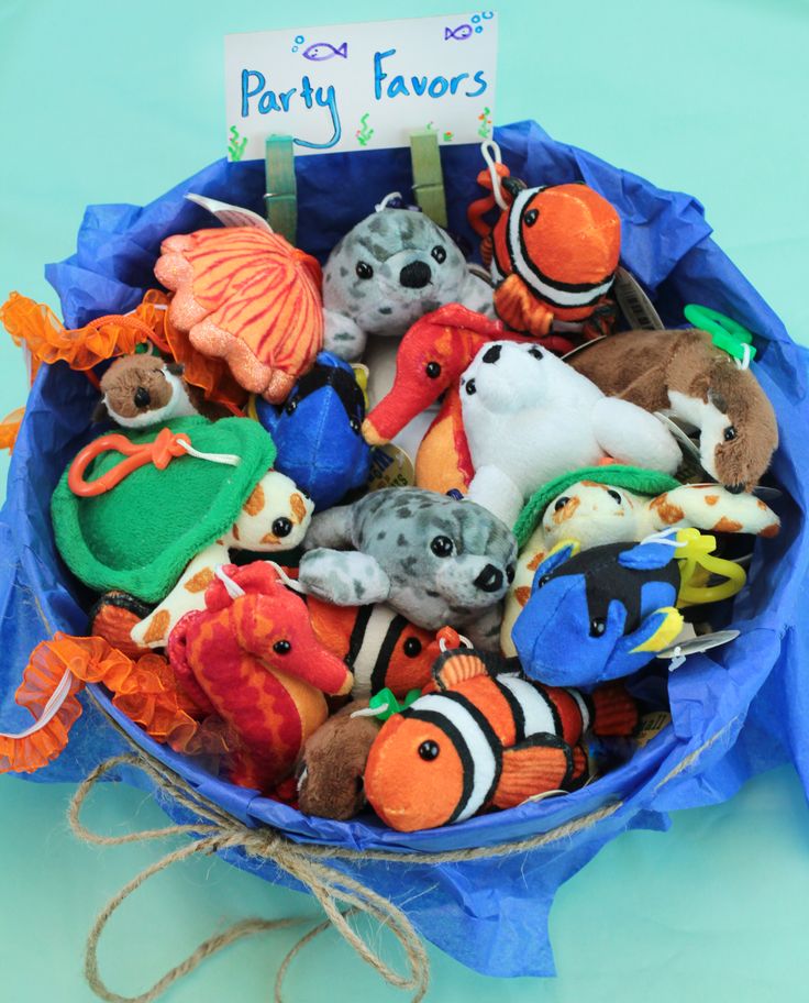 a blue basket filled with lots of stuffed animals next to a sign that says party favors