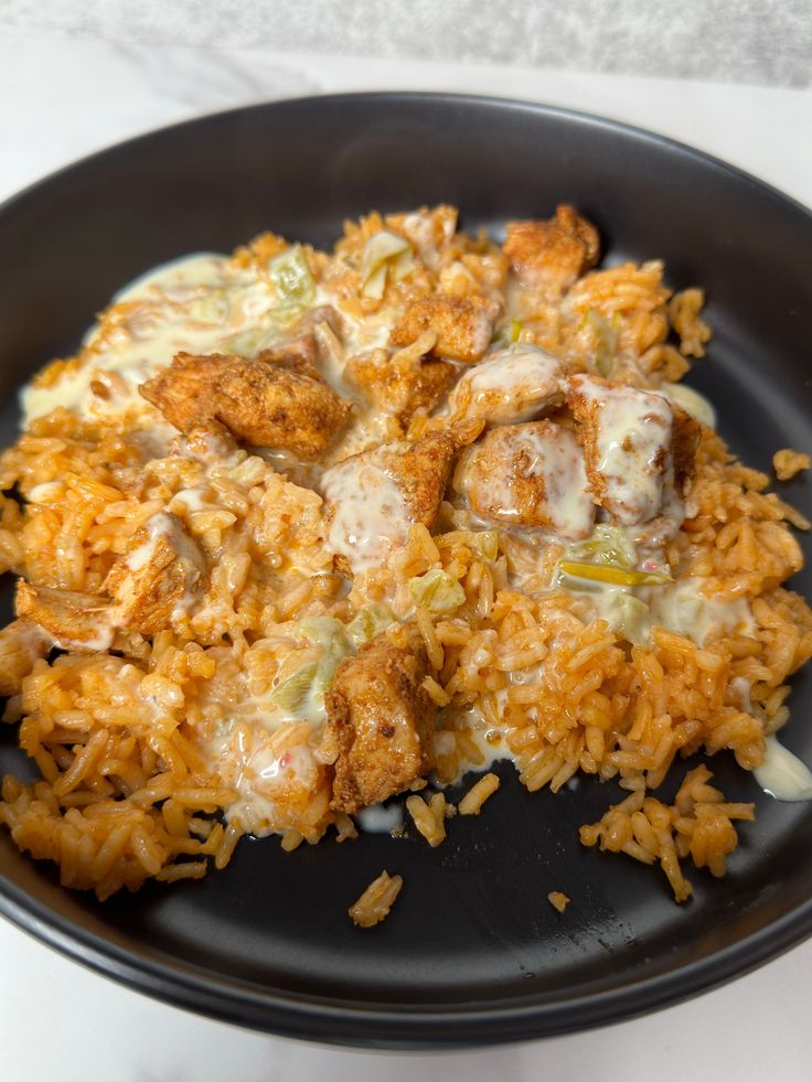 a black plate topped with rice and meat