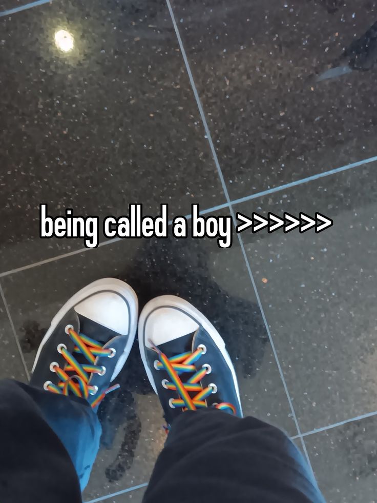 someone is standing on the floor with their feet up and wearing tennis shoes that say being called a boy