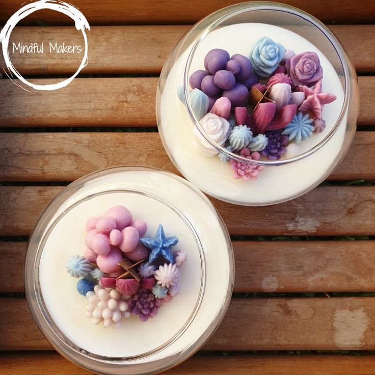 two glass bowls filled with different types of candies on top of a wooden table