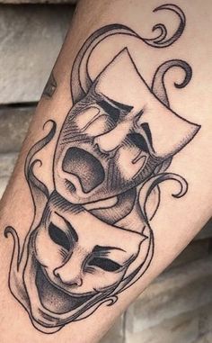 a tattoo with two masks on it