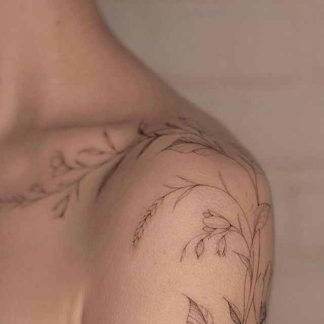 a close up of a person's shoulder with flowers on it