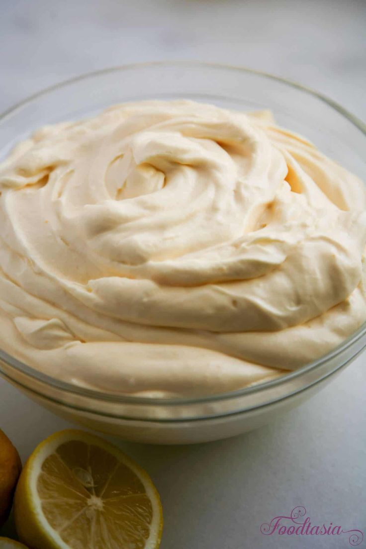 a bowl filled with whipped cream next to sliced lemons