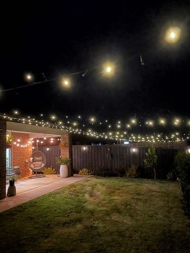 an outdoor patio with lights strung over it