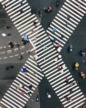 an aerial view of people crossing the street