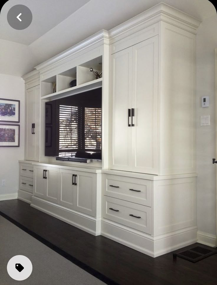 an entertainment center with white cabinets and drawers