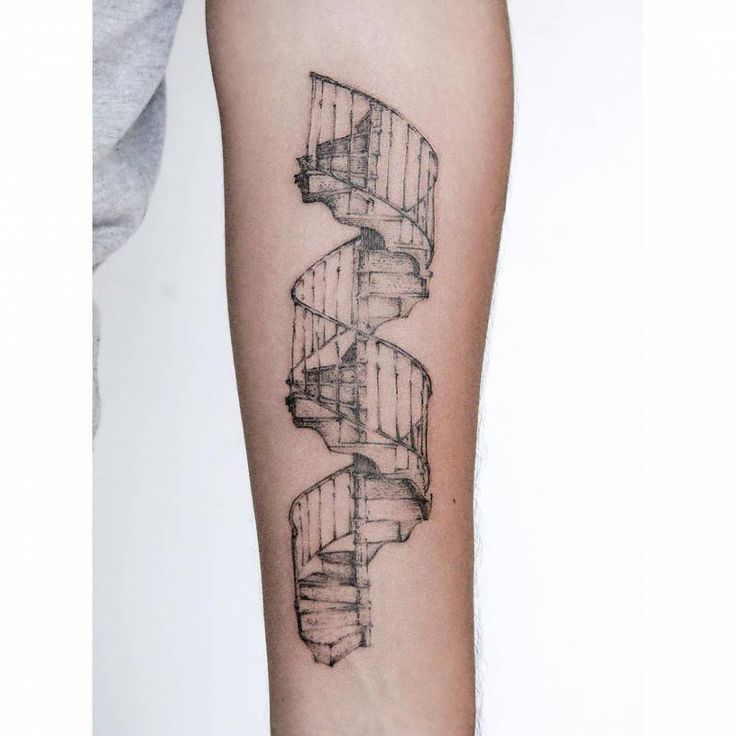 a black and white photo of a spiral staircase tattoo on the right forearm, with an abstract design