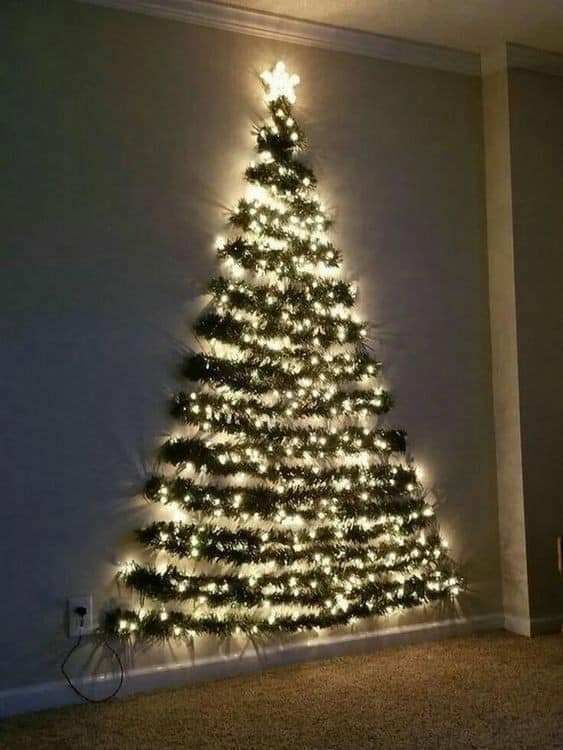 a lighted christmas tree in the corner of a room