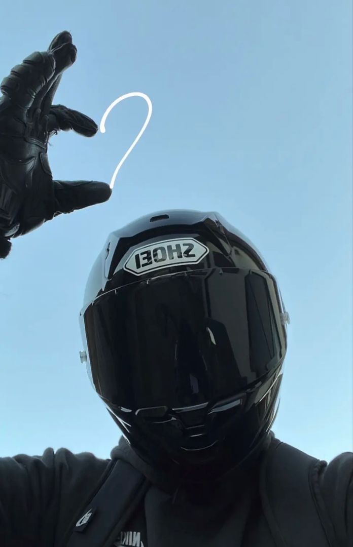 a man wearing a helmet and holding up his hand with the word shoe on it