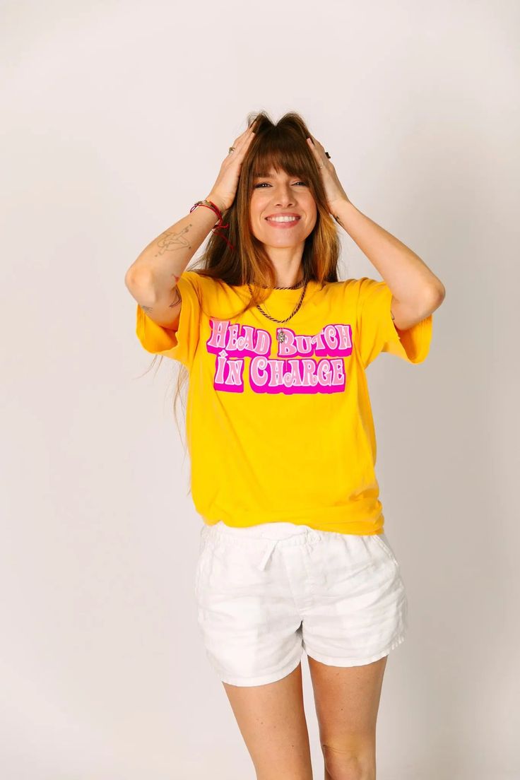 "Head Butch In Charge" screen-printed yellow shirt. Let everyone know who is really in charge with this fun shirt. Pre-shrunk, soft washed, garment dyed fabric Designed and made in New Orleans Unisex sizing Size Chart: (in inches) S M L XL 2XL 3XL Sleeve Length 8 8 ¼ 9 9 ½ 9 ¾ 9 ¾ Full Body Length 27 28 ½ 30 31 ½ 32 ¾ 33 Body Width 18 ½ 20 ½ 22 ½ 24 ½ 26 ½ 28 Yellow Graphic Print Band Merch Top, Retro Yellow T-shirt With Slogan, Yellow Top With Funny Print For Streetwear, Yellow Cotton T-shirt With Funny Print, Trendy Yellow Shirt With Screen Print, Yellow Cotton T-shirt With Screen Print, Relaxed Fit Yellow T-shirt With Text Print, Yellow Relaxed Fit T-shirt With Text Print, Yellow Cotton Top With Funny Print