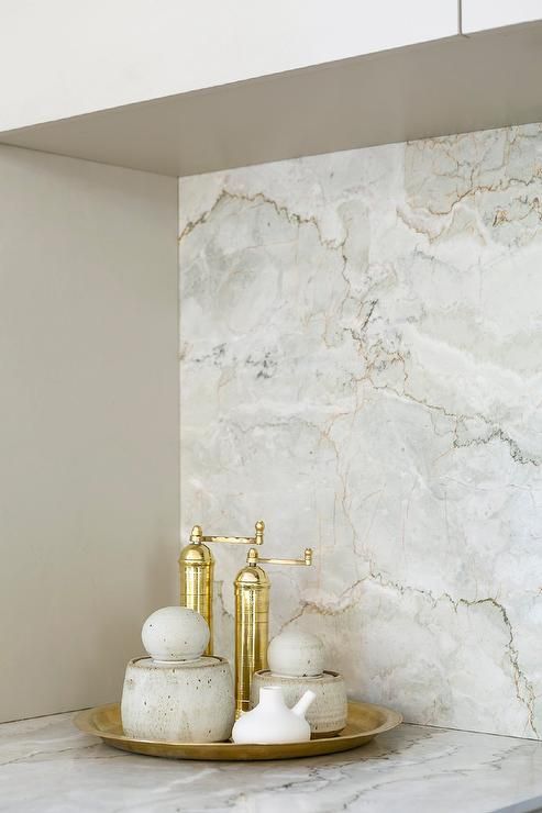 a bathroom with marble counter tops and gold faucets