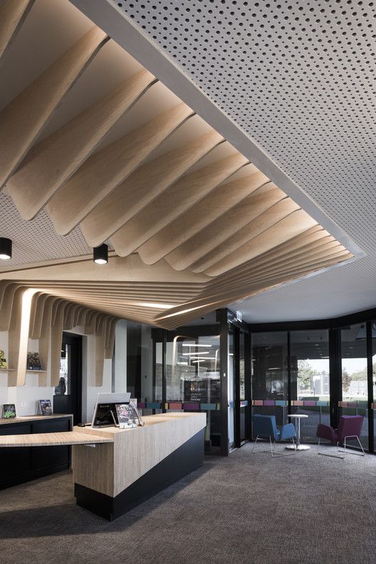 the interior of an office building with modern furniture and lighting on each side of the room