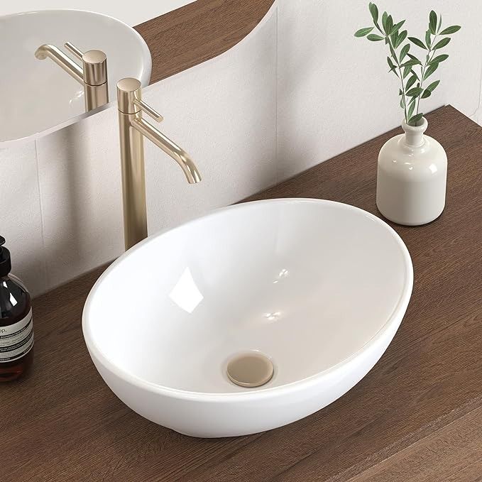 a white sink sitting on top of a wooden counter next to a faucet