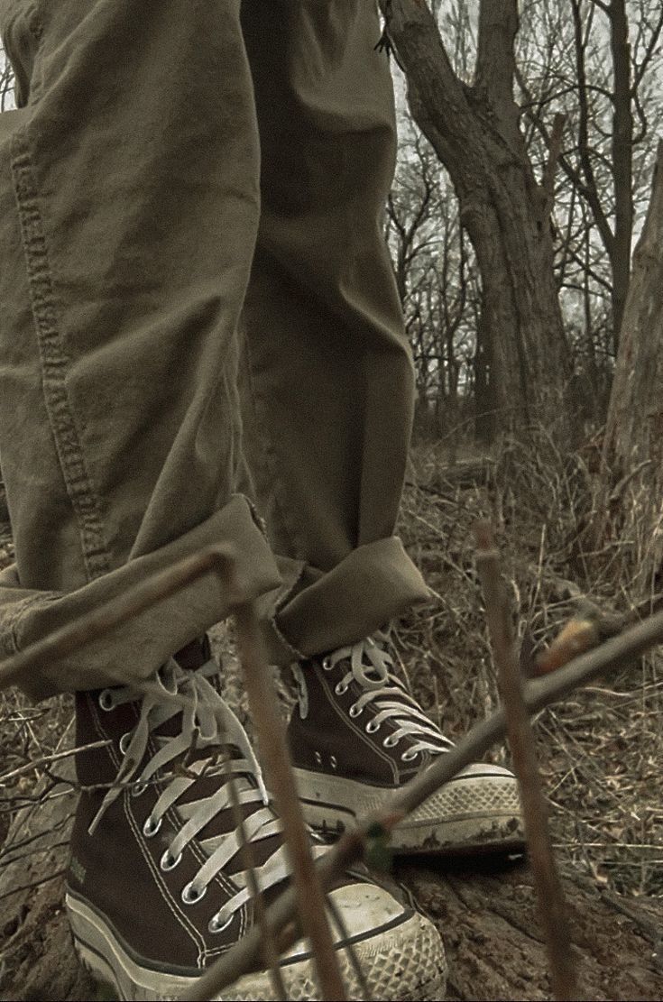 a person standing in the woods with their shoes on