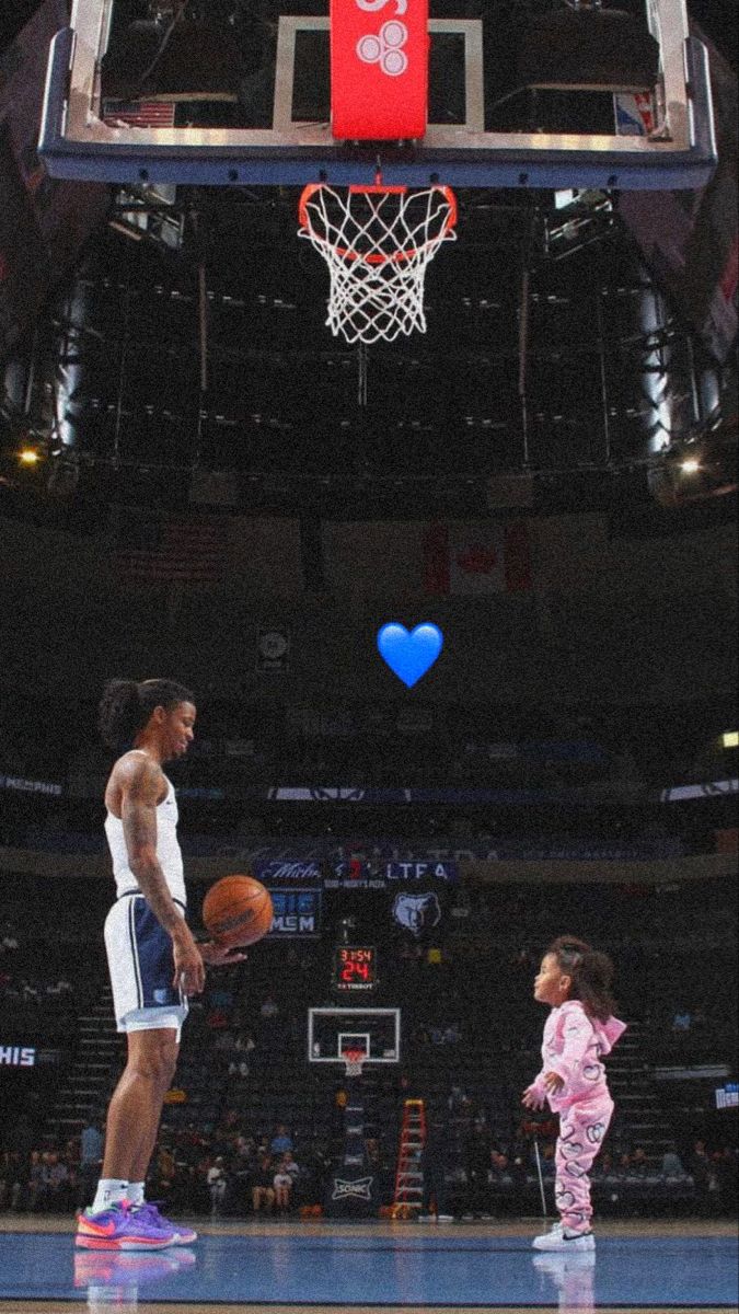 two basketball players standing on a court with a ball in their hands and one holding a basket