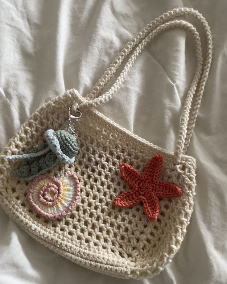 a crocheted purse with starfish and seashells hanging from it's handle