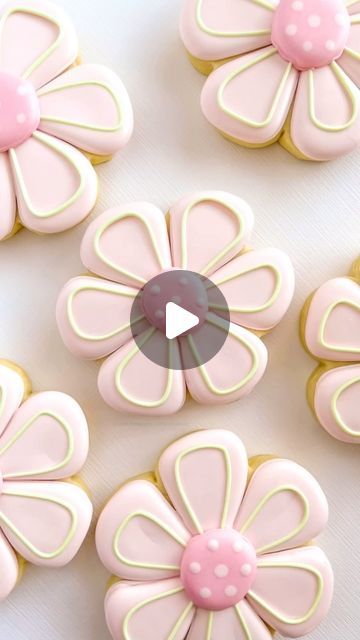 some pink and white cookies with flowers on them