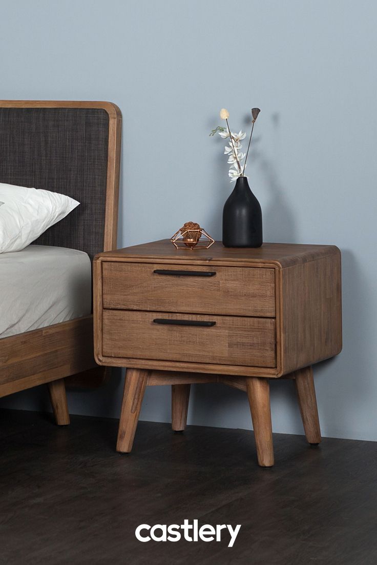 a nightstand with two drawers next to a bed