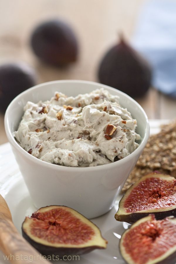 a white bowl filled with food on top of a plate next to sliced figs