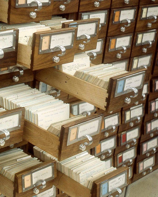 many files are stacked on top of each other in this room filled with wooden file cabinets