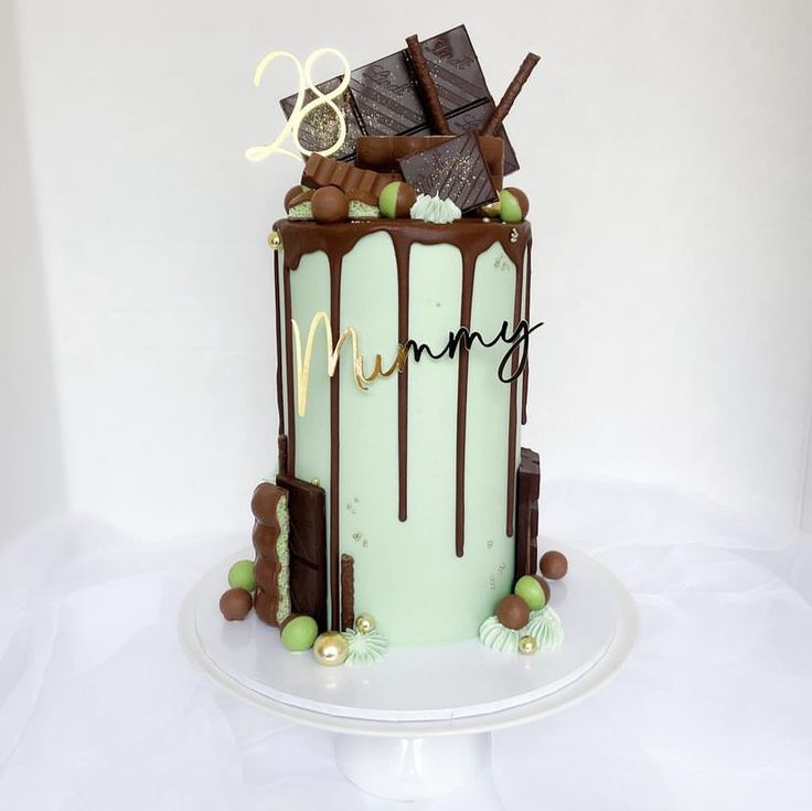 a cake with chocolate and mint green icing on a white tableclothed surface