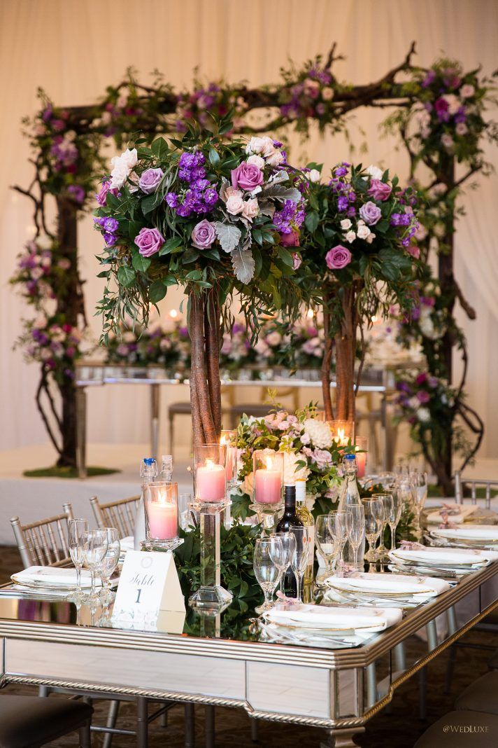 the table is set with candles, flowers and greenery for an elegant wedding reception