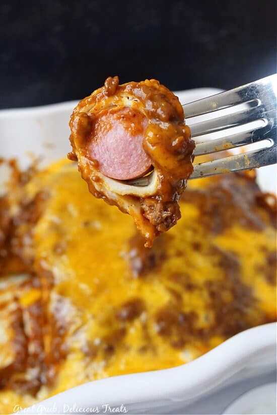 a fork with some food on it in a casserole dish that is ready to be eaten