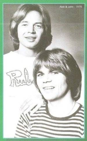 an old photo of two people in front of a green and white card with the words,