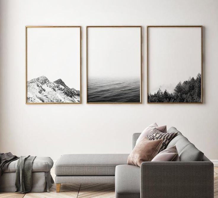 three black and white pictures hang on the wall above a couch in a living room