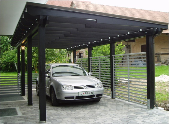 a car is parked in the driveway under an awning