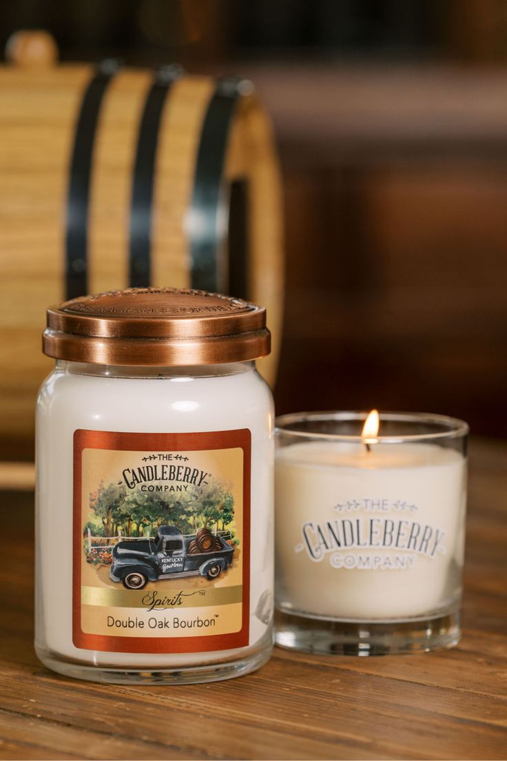 a candle sitting on top of a wooden table next to a glass jar filled with candles