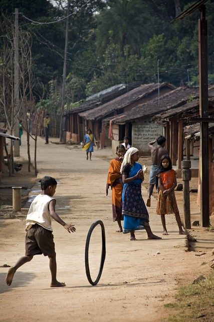 a group of people playing with a frisbee on a dirt road