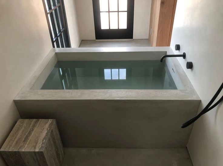 an indoor hot tub in the middle of a room with stairs leading up to it