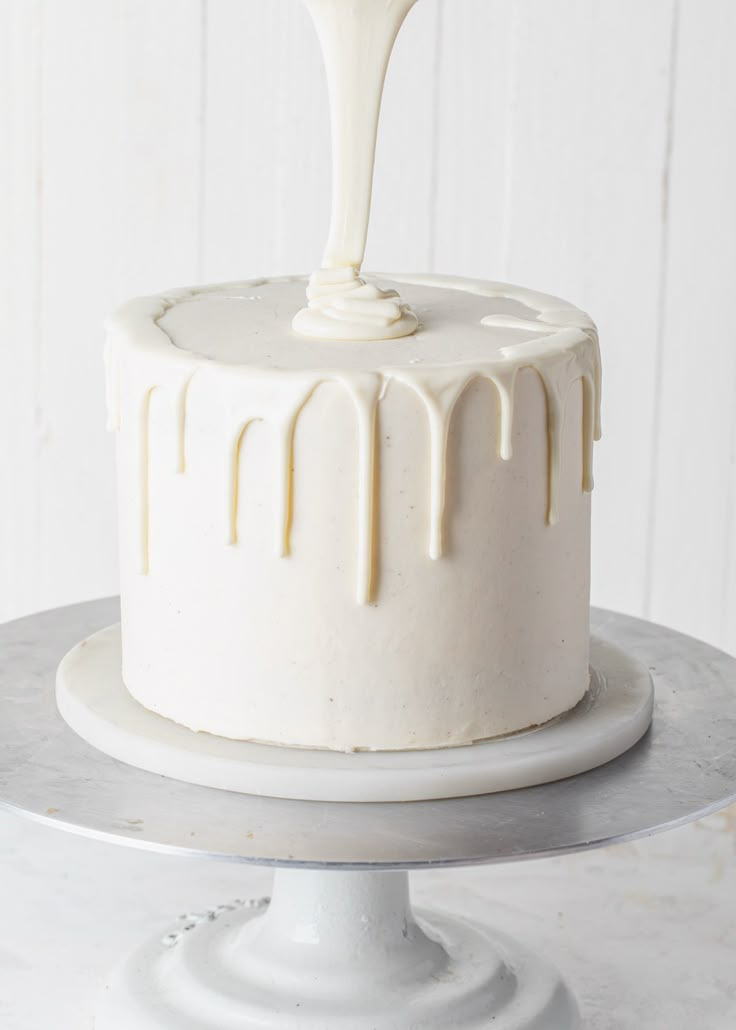 a white cake with icing dripping from it