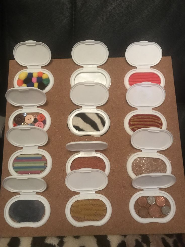 the contents of an open makeup case on a leopard print surface, including several different types of eyeshades