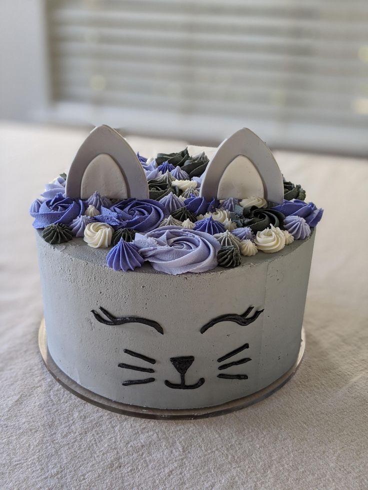 a cake decorated with flowers and an animal's face