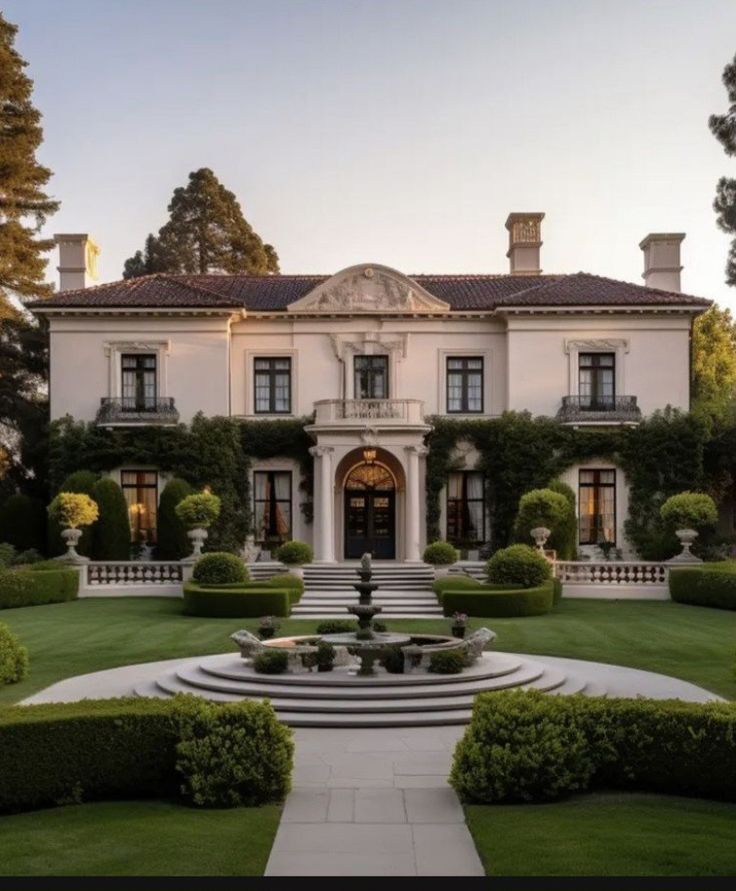 a large white house surrounded by trees and bushes