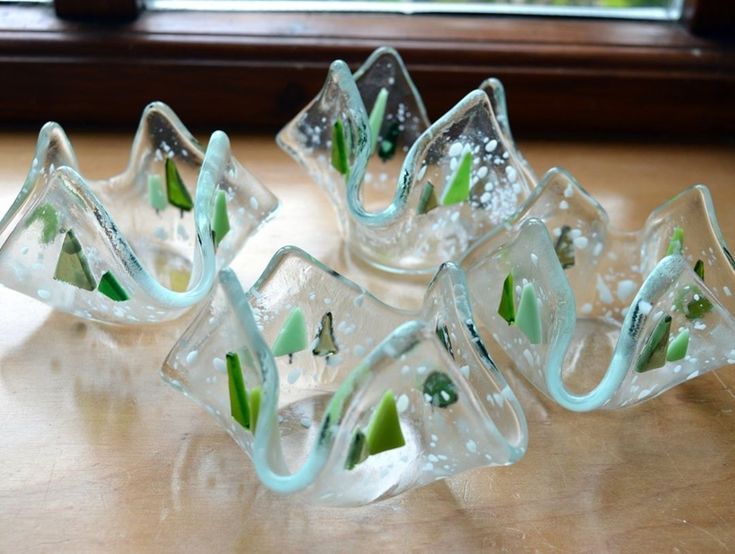 four glass vases sitting on top of a wooden table