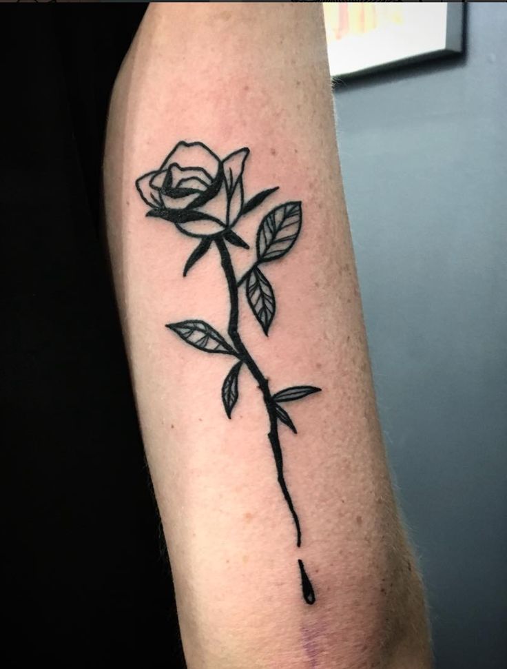 a black rose tattoo on the arm