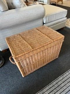 a living room filled with furniture and a wicker basket on the floor next to a couch