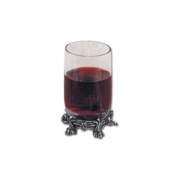 a glass filled with red liquid sitting on top of a metal stand next to a white wall