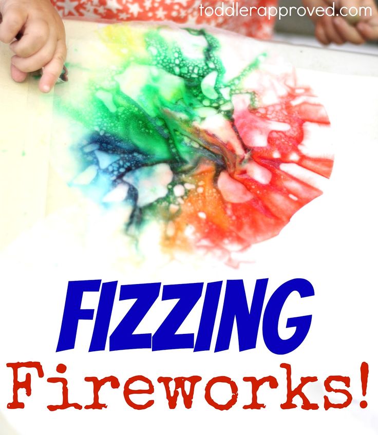 a child's hands holding a piece of paper with the words fizzing fireworks on it