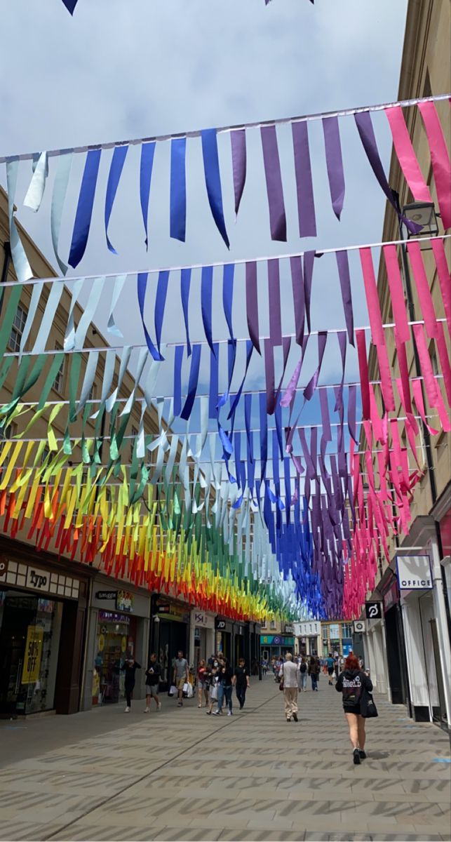 people walking down the street under colorful streamers