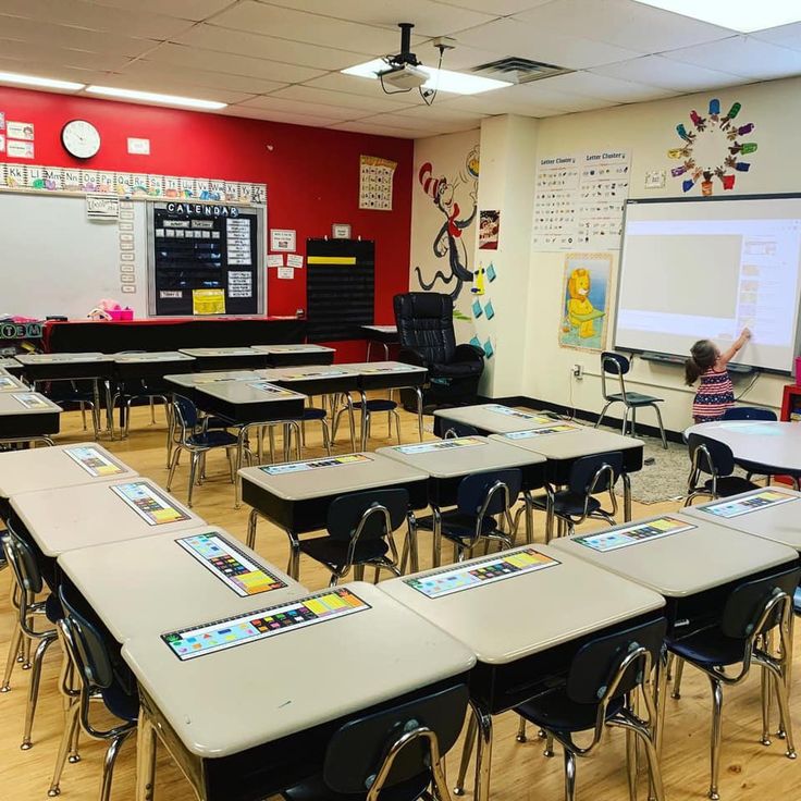 an empty classroom with desks and chairs in front of a white board on the wall