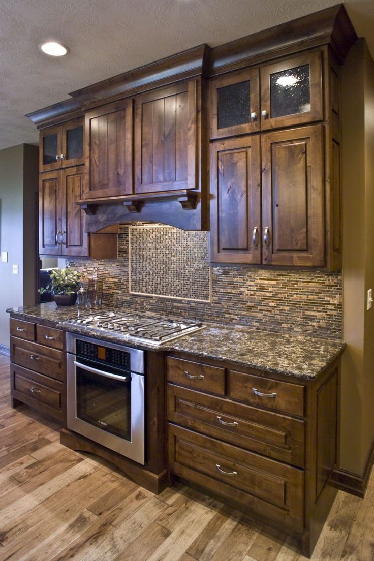 a kitchen with wooden cabinets and granite counter tops in the center, along with stainless steel appliances