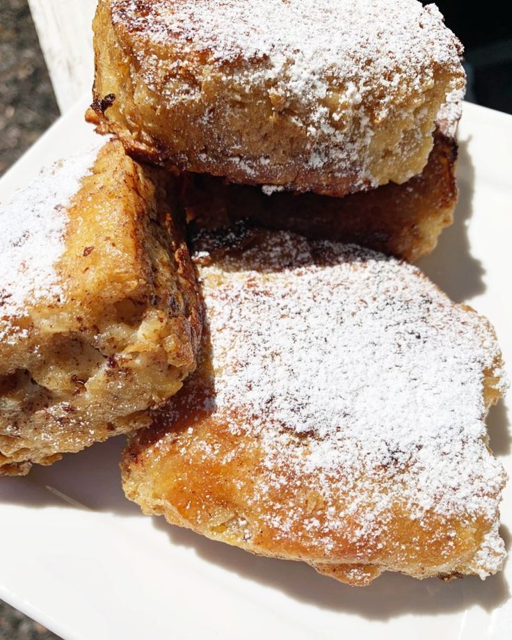 powdered sugar covered pastries on a white plate