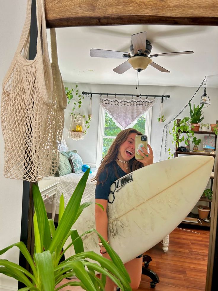 a woman holding a white surfboard in her hand