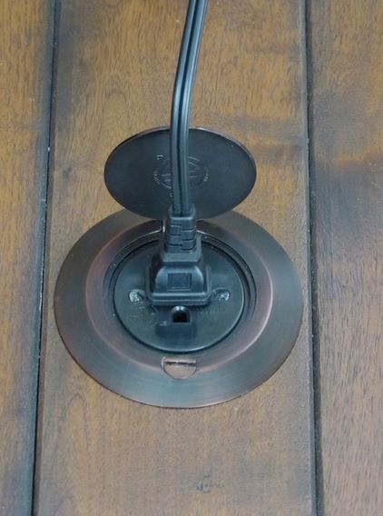 an electronic device is plugged in to a wall outlet on a wood flooring surface