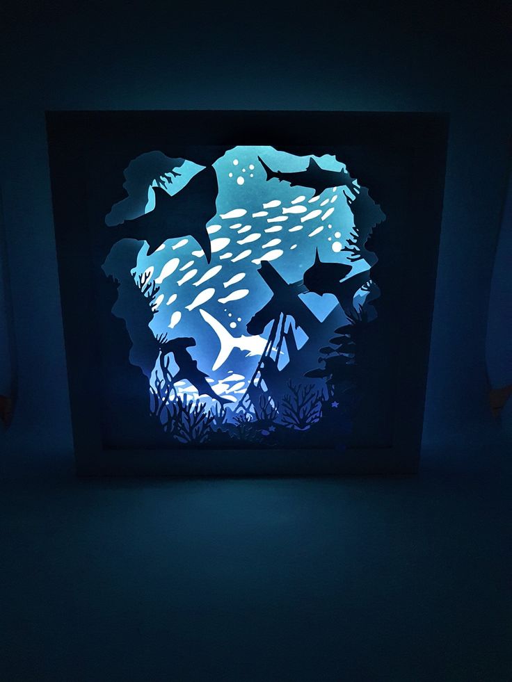 an underwater scene is projected in the dark