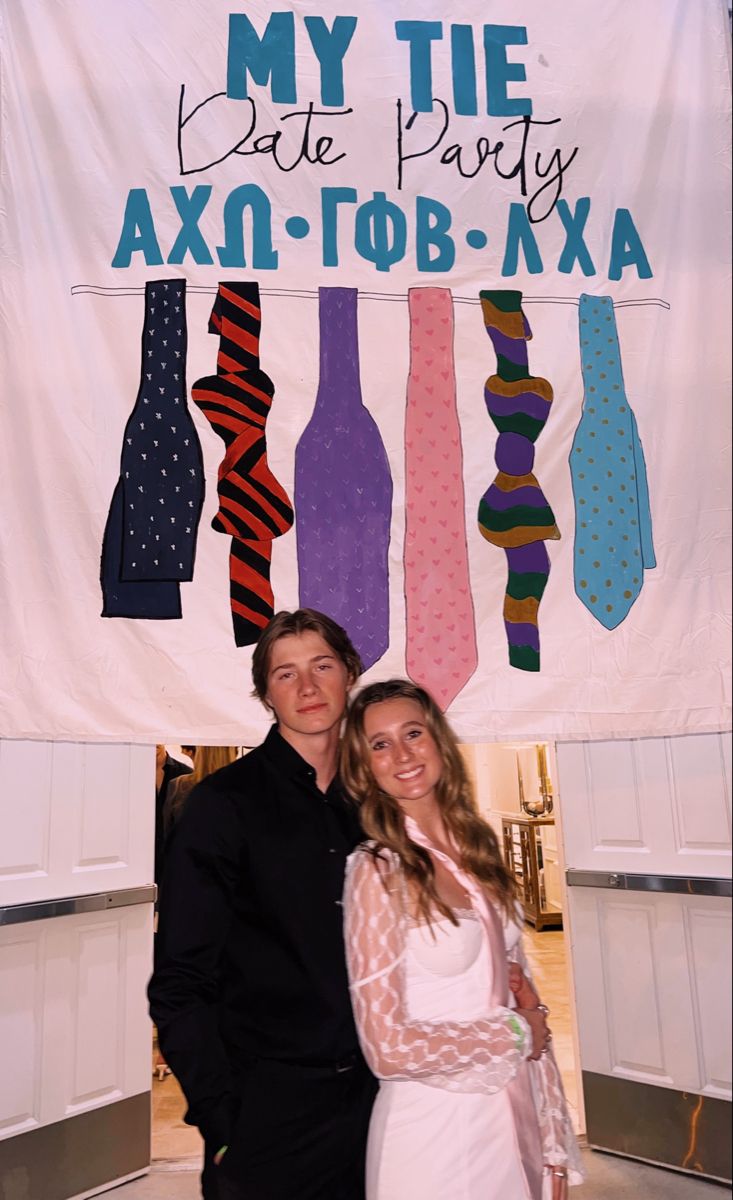 a man and woman standing in front of a sign that says my tie party axq - tob - xxa